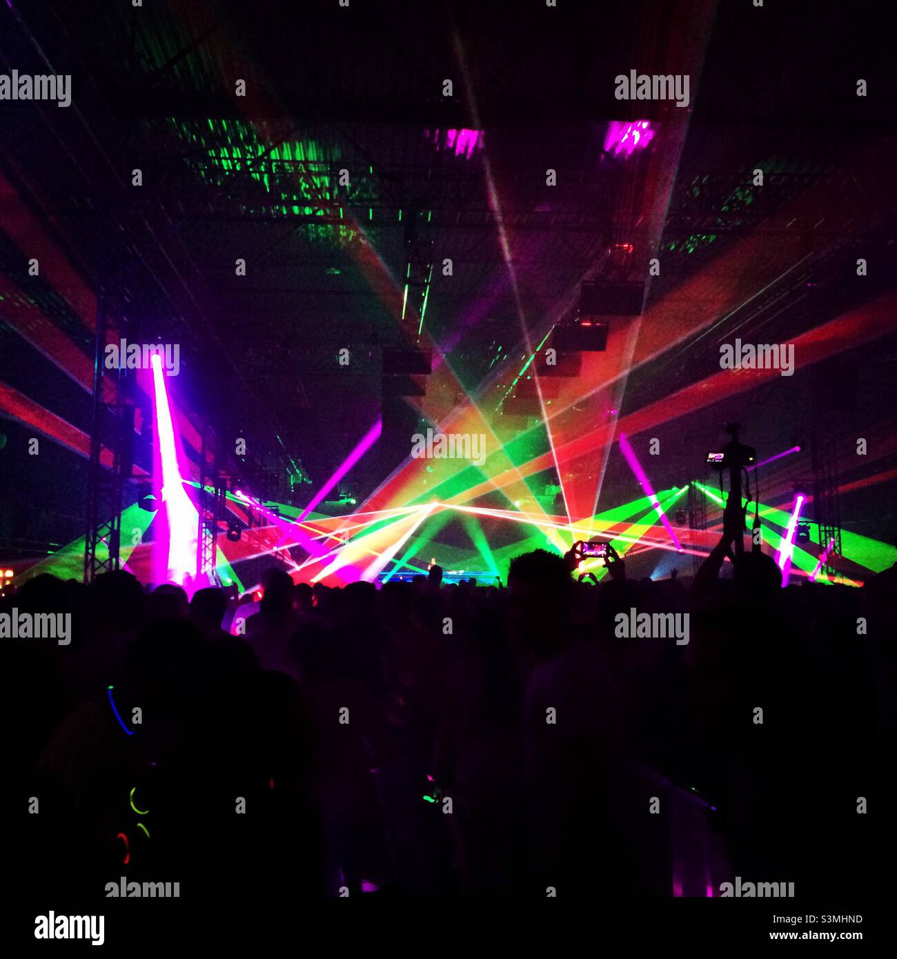 Silhouette di persone e laser a una festa di musica da ballo elettronica. Foto Stock