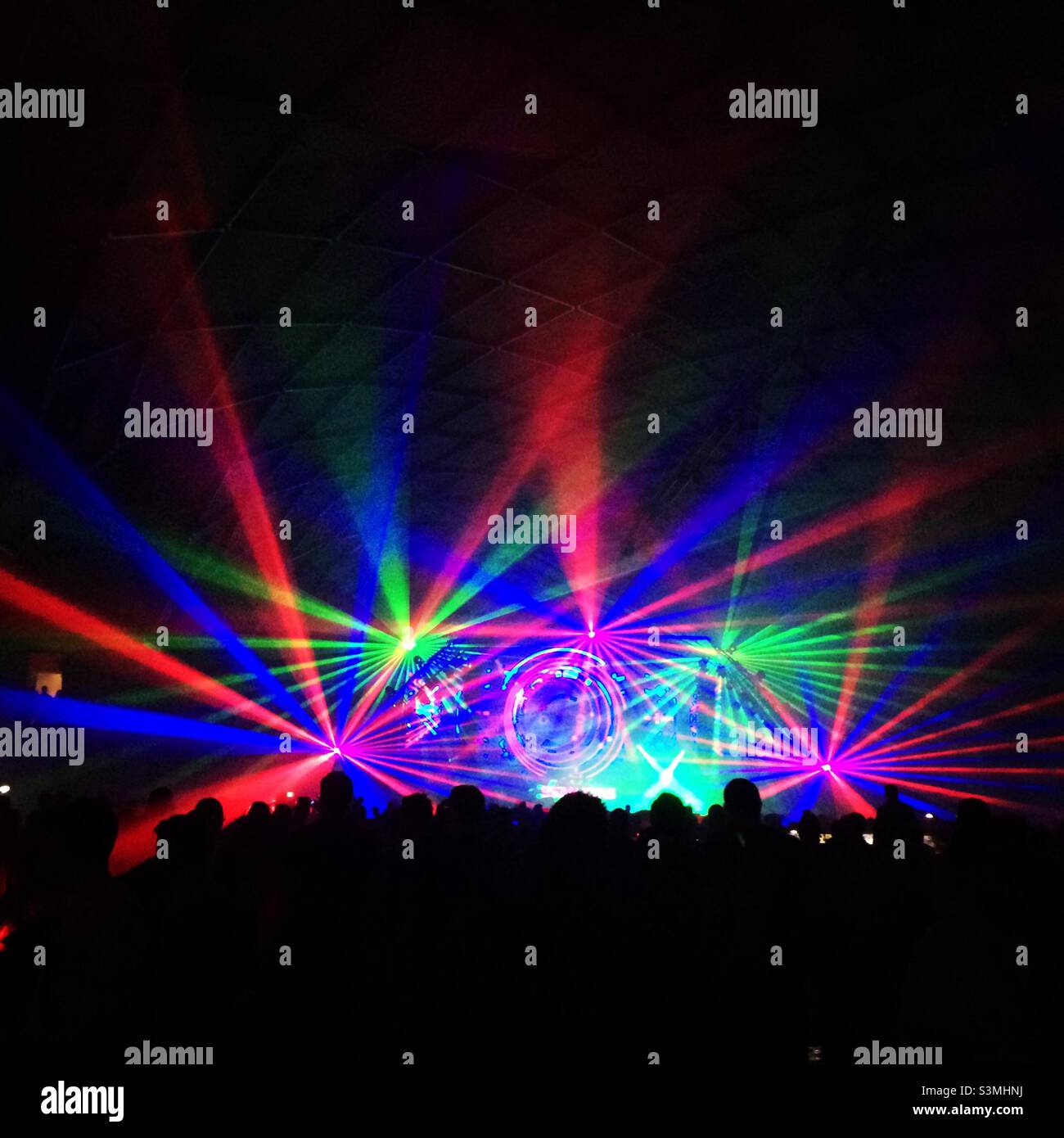 Silhouette di persone e laser a una festa di musica da ballo elettronica. Foto Stock