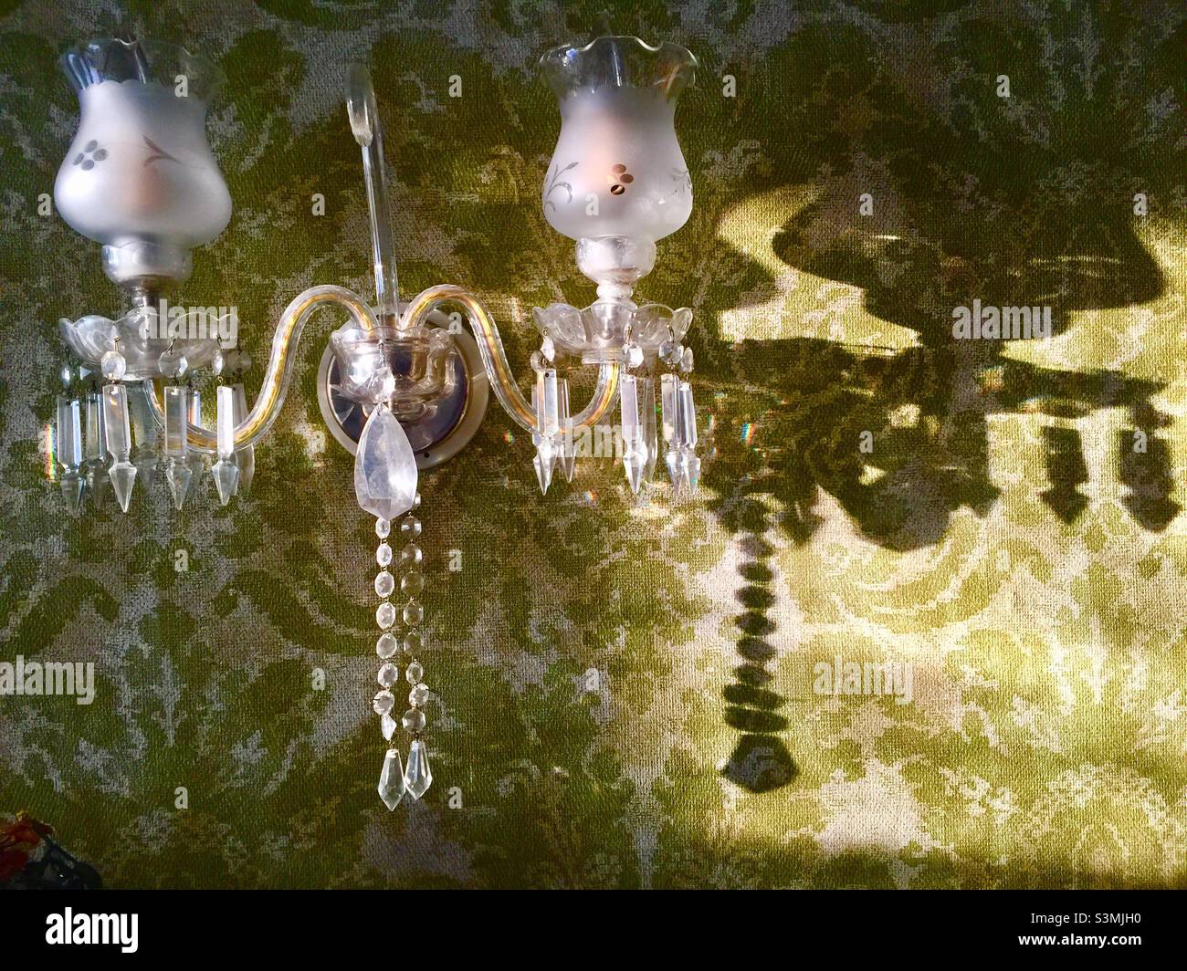 Apparecchio di illuminazione classico, con cristallo e vetro inciso, su una parete, Ontario, Canada. Design della carta da parati ispirato ai modelli dei primi anni del 20th. - Immagine stock catturata con smartphone