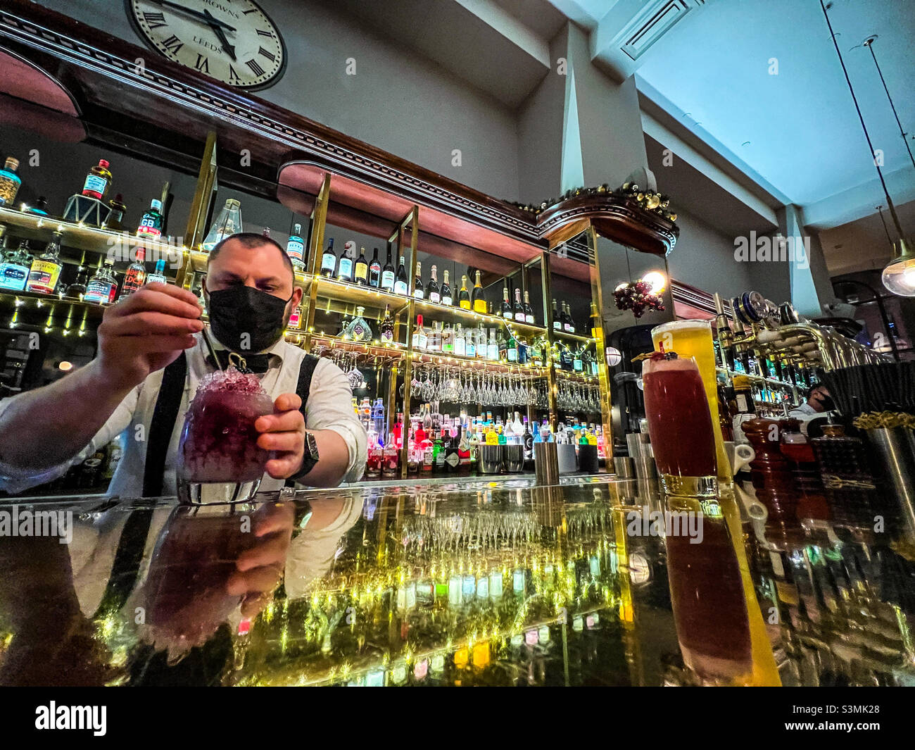 Barista che serve cocktail al bar di Leeds Foto Stock