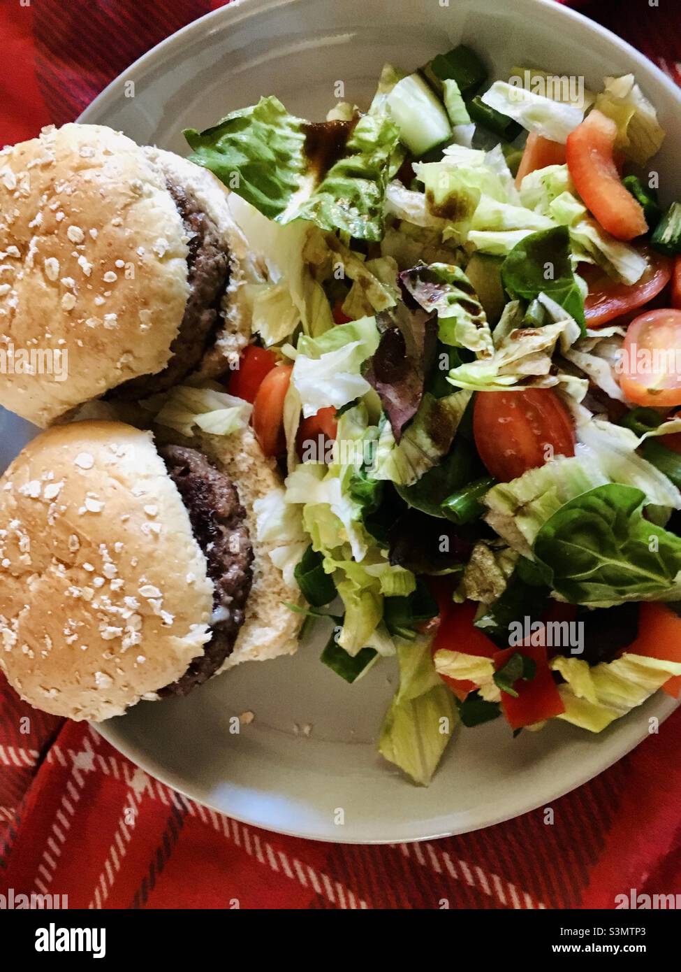 Picnic barbecue in Scozia. Hamburger con insalata su una coperta da picnic con tartan Foto Stock