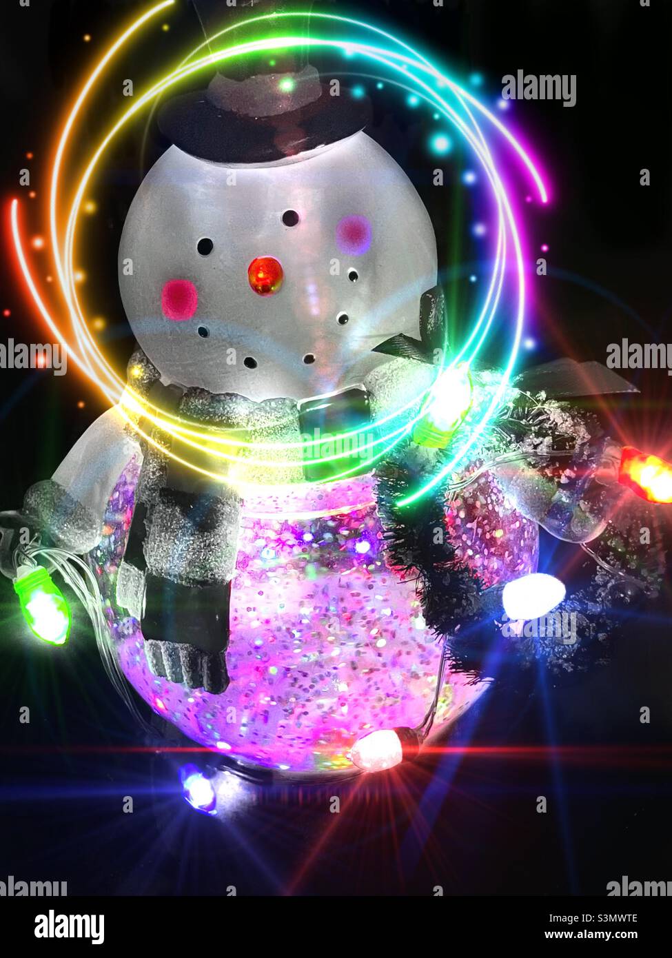 Una decorazione natalizia divertente e unica, una sorta di ibrido tra un pupazzo di neve e un globo di neve. Alcuni effetti di luce aggiuntivi sono stati aggiunti tramite l'app IOS LensLight. - Immagine stock catturata con smartphone