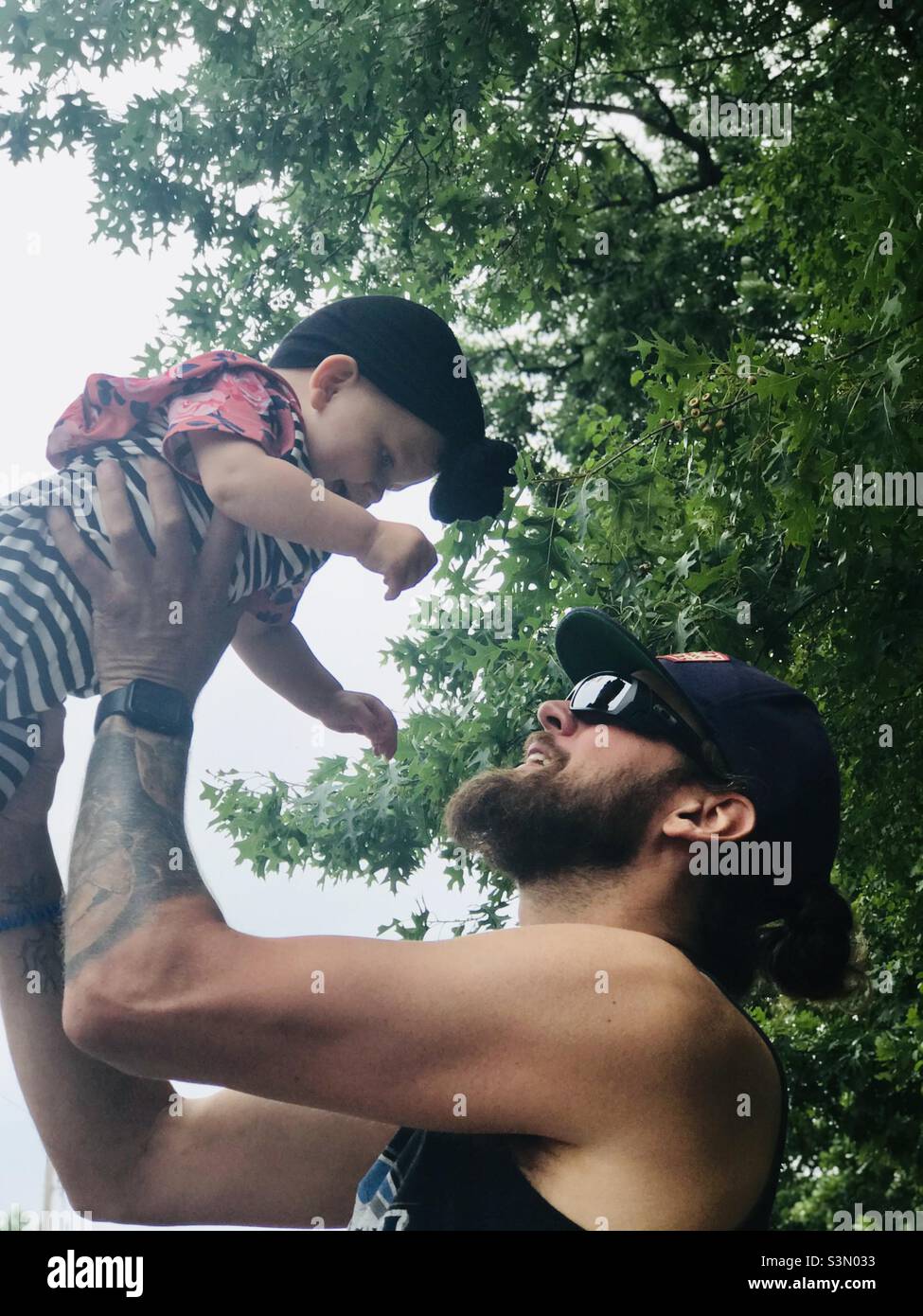 Padre che interagisce con la figlia che la tiene in aria Foto Stock