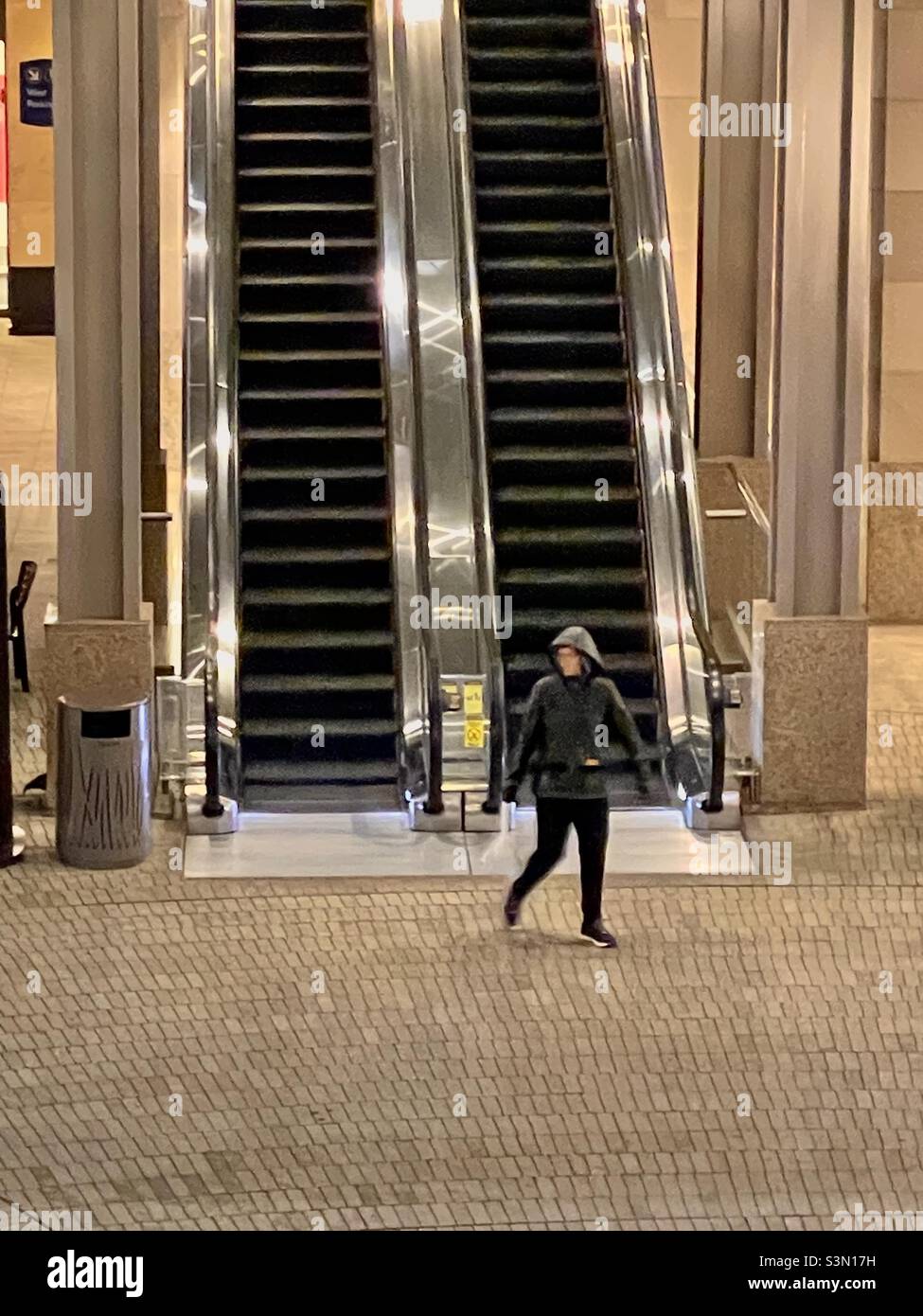 Donna che scenderà dalla scala mobile al City Creek Center, a Salt Lake City, Utah, USA. Foto Stock