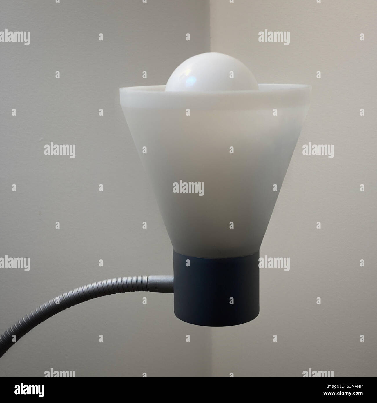 Lampadina bianca in una lampada con braccio flessibile - Immagine stock catturata con smartphone