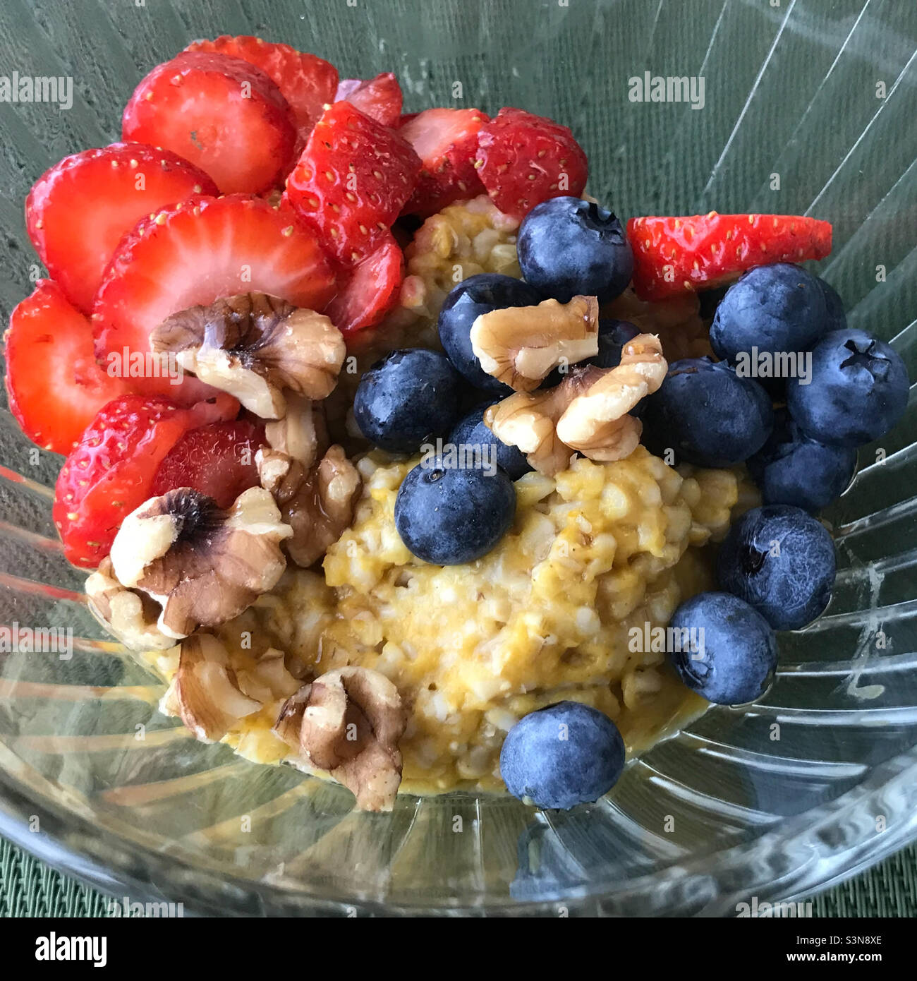 Fiocchi d'avena tagliati in acciaio di zucca con fragole fresche, mirtilli e noci. Foto Stock