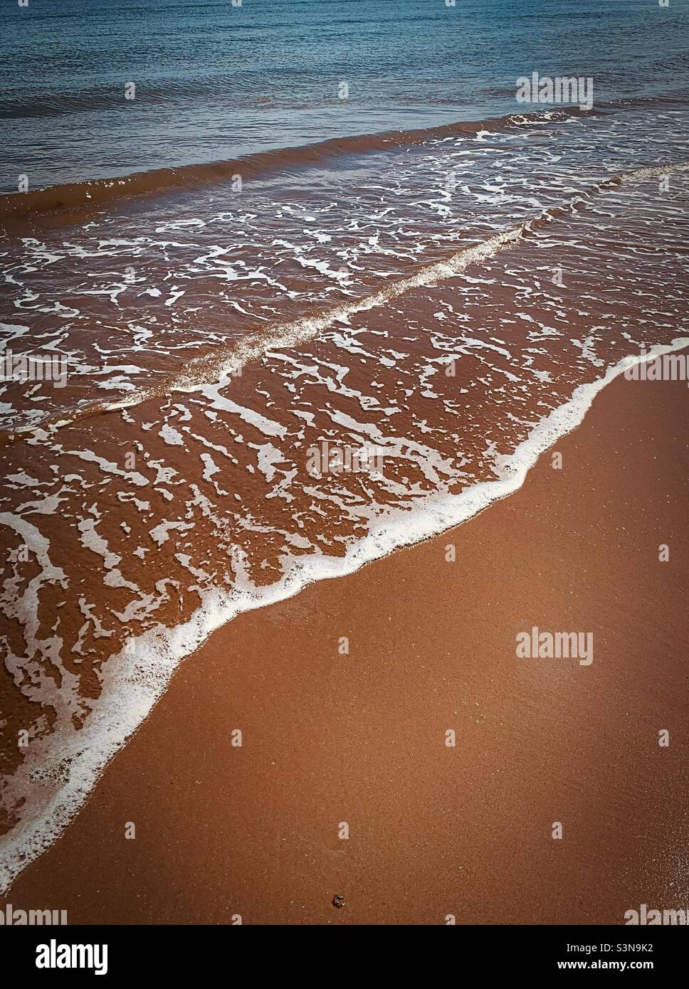 Le onde di ‘Serenity’ spennellano delicatamente la sabbia sulla spiaggia di cui sono fatti i sogni Foto Stock