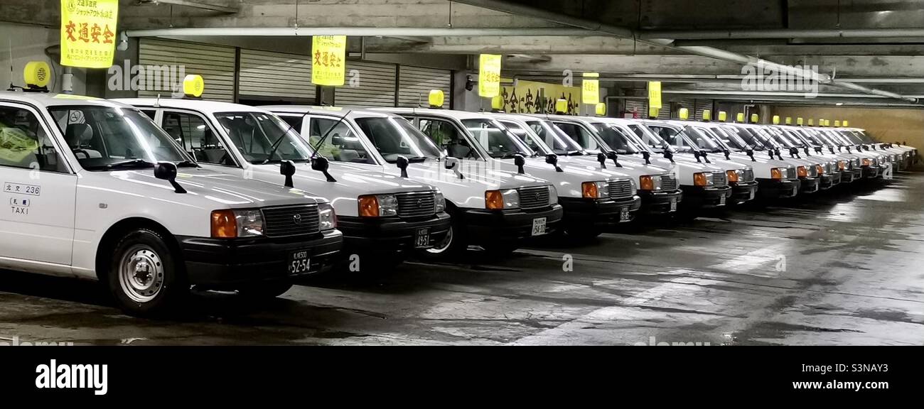 Una lunga fila di taxi giapponesi Toyota comfort a Sapporo, Giappone. Foto Stock