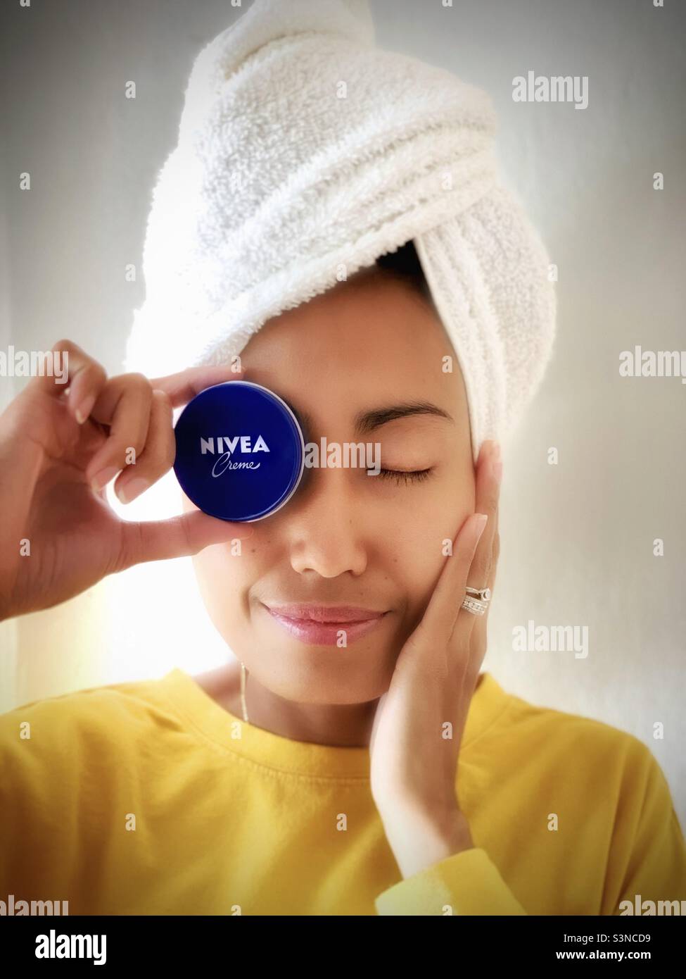 Una donna che tiene un Nivea su sfondo bianco - Immagine stock catturata con smartphone