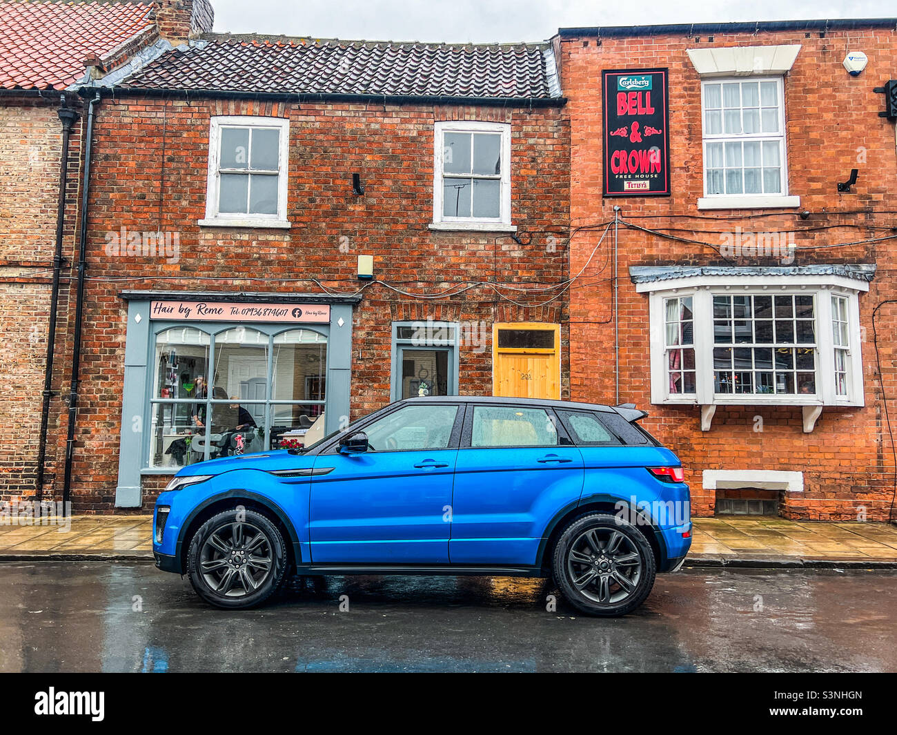 Range Rover Evoque blu brillante parcheggiata su strada nel villaggio urbano Foto Stock