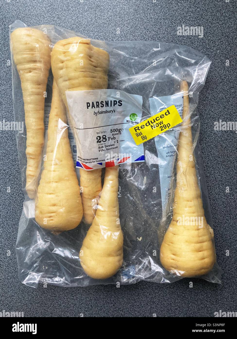 Crisi del costo della vita, aumento dei prezzi del cibo, alla ricerca di occasioni e budget, Un sacchetto di pastinaca sativa a prezzi ridotti da Sainsbury Foto Stock