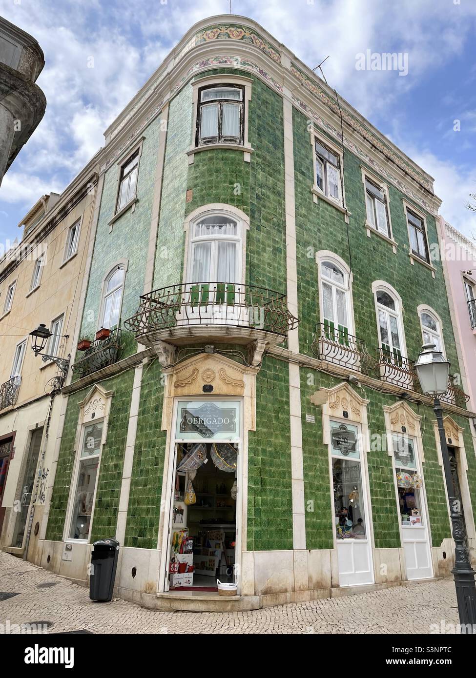 Edificio ad angolo commerciale piastrellato di verde Foto Stock