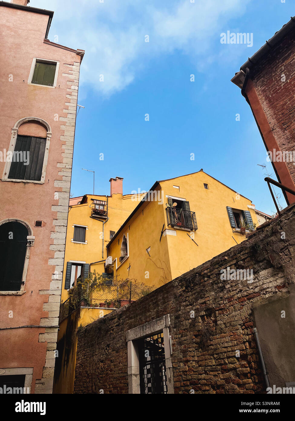 Colorati edifici residenziali a Venezia, Italia con cielo blu in una giornata di febbraio soleggiata. Foto Stock