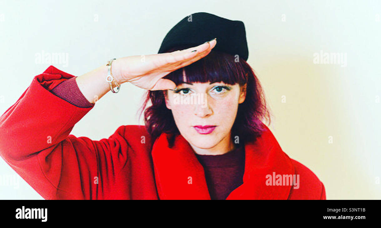 Ritratto di una donna che indossa giacca rossa saluto in stile militare Foto Stock