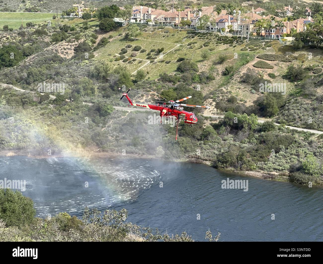 Elicottero antincendio che sorvola il lago artificiale del distretto di Trabuco Canyon Foto Stock