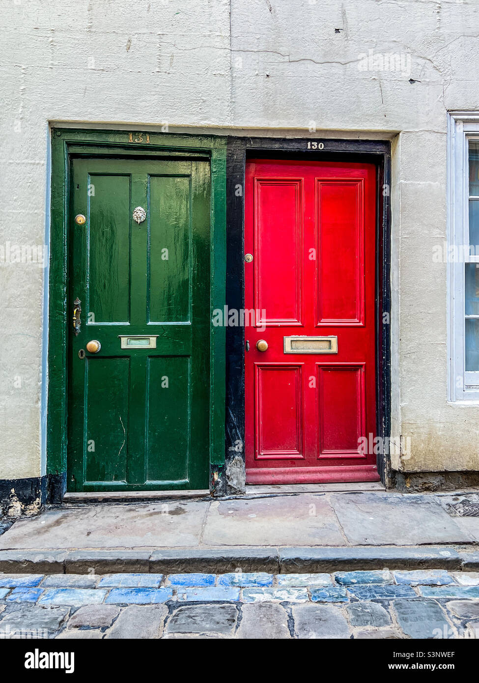 Porte verdi e rosse sulla strada acciottolata a Whitby Foto Stock