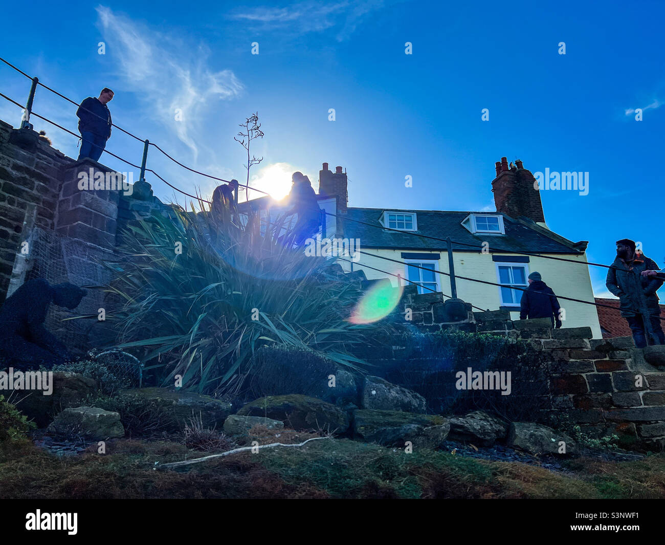 Persone che camminano sui 199 gradini su Church Lane a Whitby Foto Stock