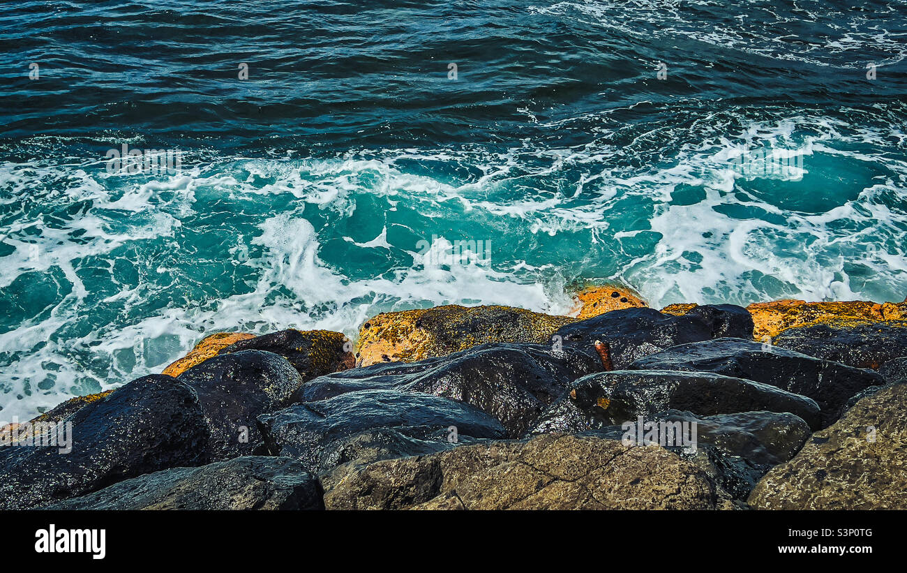 Sfondo marino con schiuma di mare da spruzzi di rocce da forti onde di colore blu in spiaggia di Alii, sulla costa settentrionale, isola di Oahu Hawaii Foto Stock