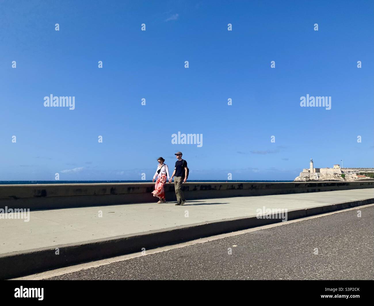 Coppia camminando lungo il lungomare 'El Malecón' a l'Avana, Cuba, Caraibi. Paesaggio urbano di Havana nel 2022 - Immagine stock catturata con smartphone