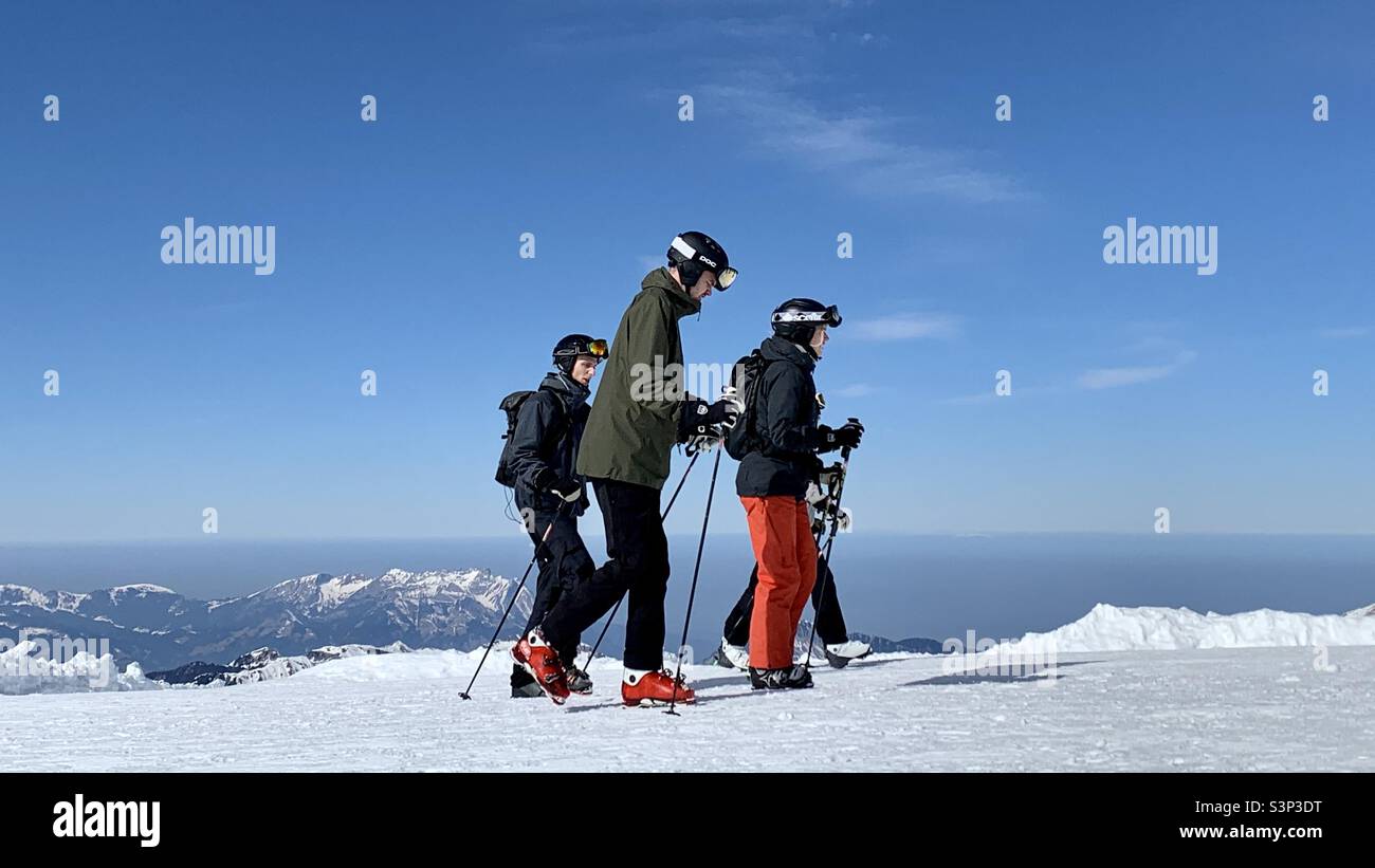 Quattro sciatori che camminano sulla cima del Monte Titlis sopra Engelberg, Svizzera. Foto Stock