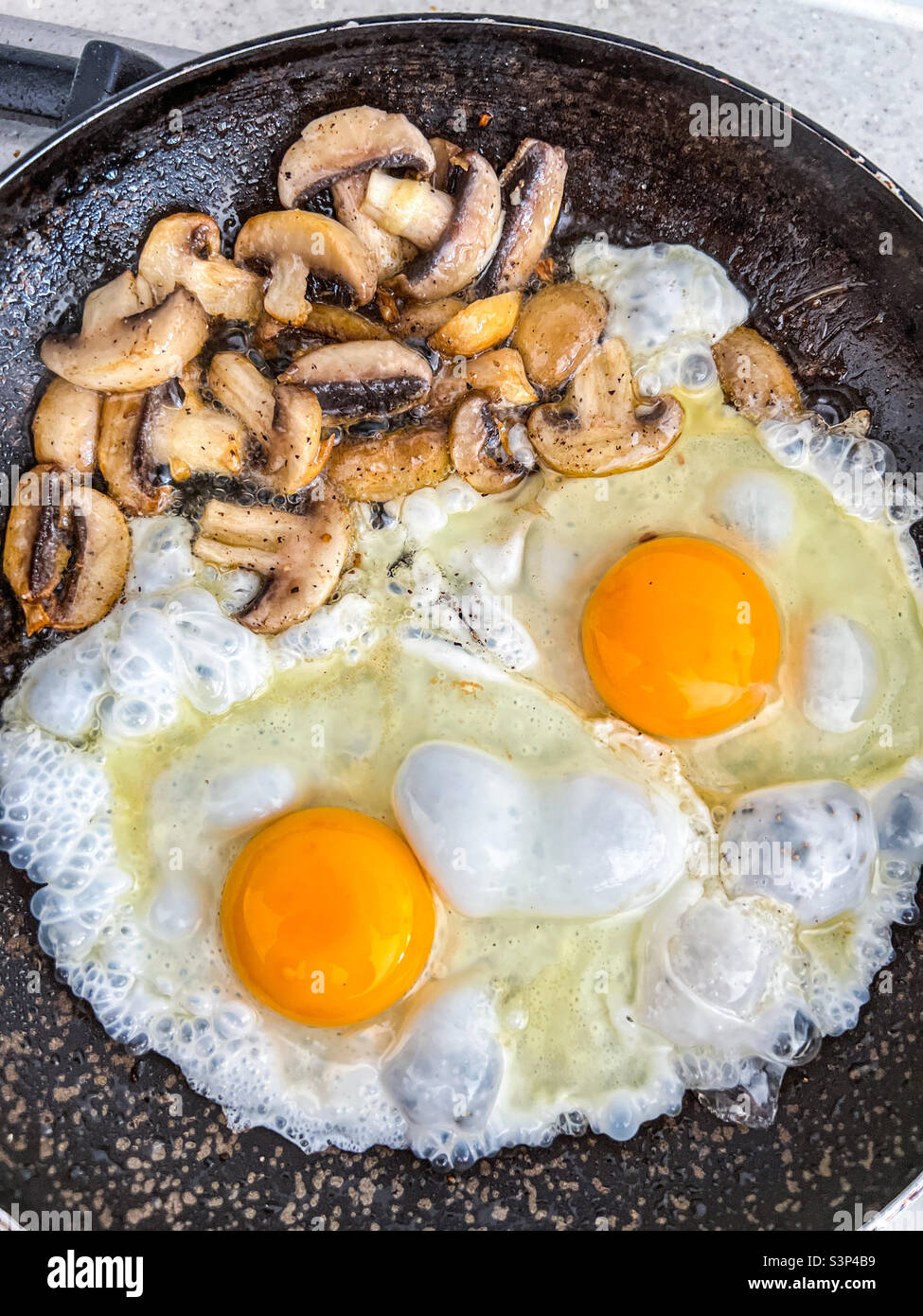 Uova e funghi in una padella Foto Stock