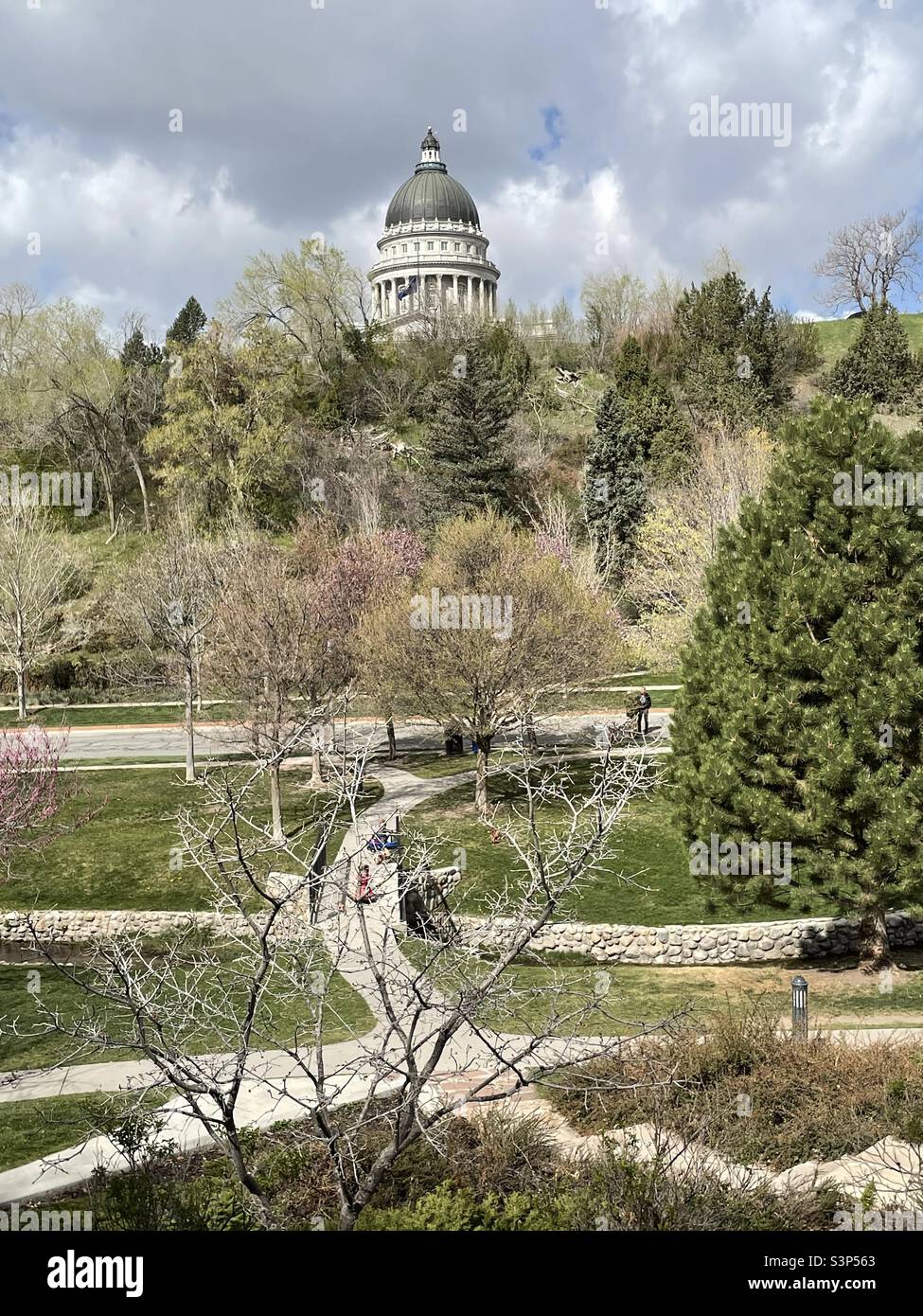Una vista sul Memory Grove Memorial Park di Salt Lake City, Utah, USA in primavera. Potete fare fuori alcune persone che si fresano circa sul terreno e il Campidoglio di Stato sullo sfondo. - Immagine stock catturata con smartphone