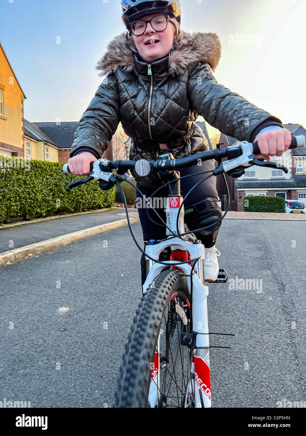Giovane ragazza che guida la sua mountain bike in strada Foto Stock
