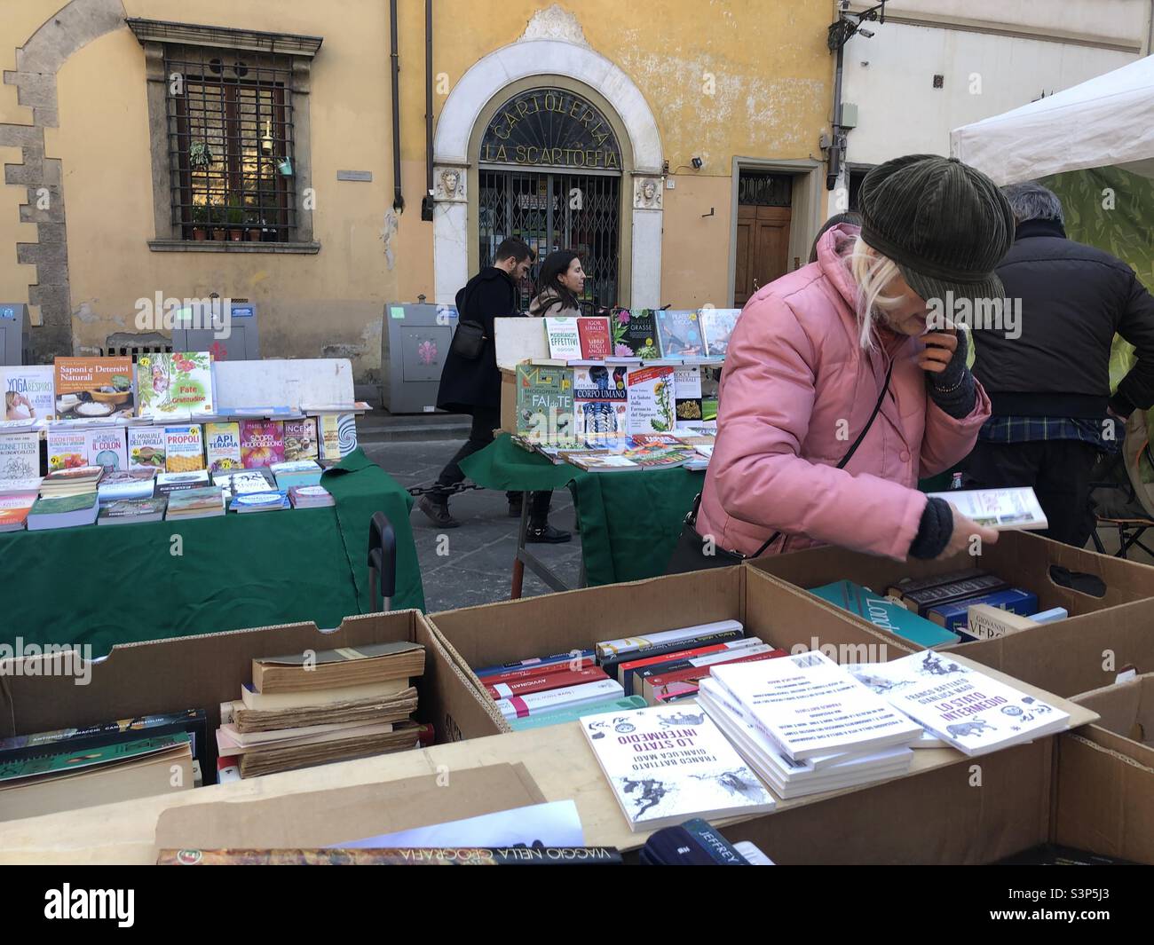 Signora in un libro stalla in un mercato di strada in Italia Foto Stock