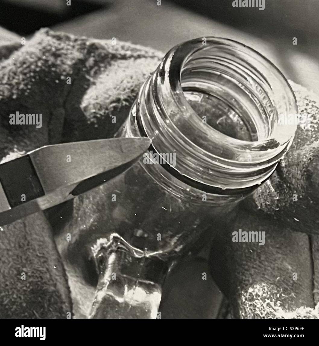 Separazione del metallo dal collo del flacone di vetro per il riciclaggio Foto Stock
