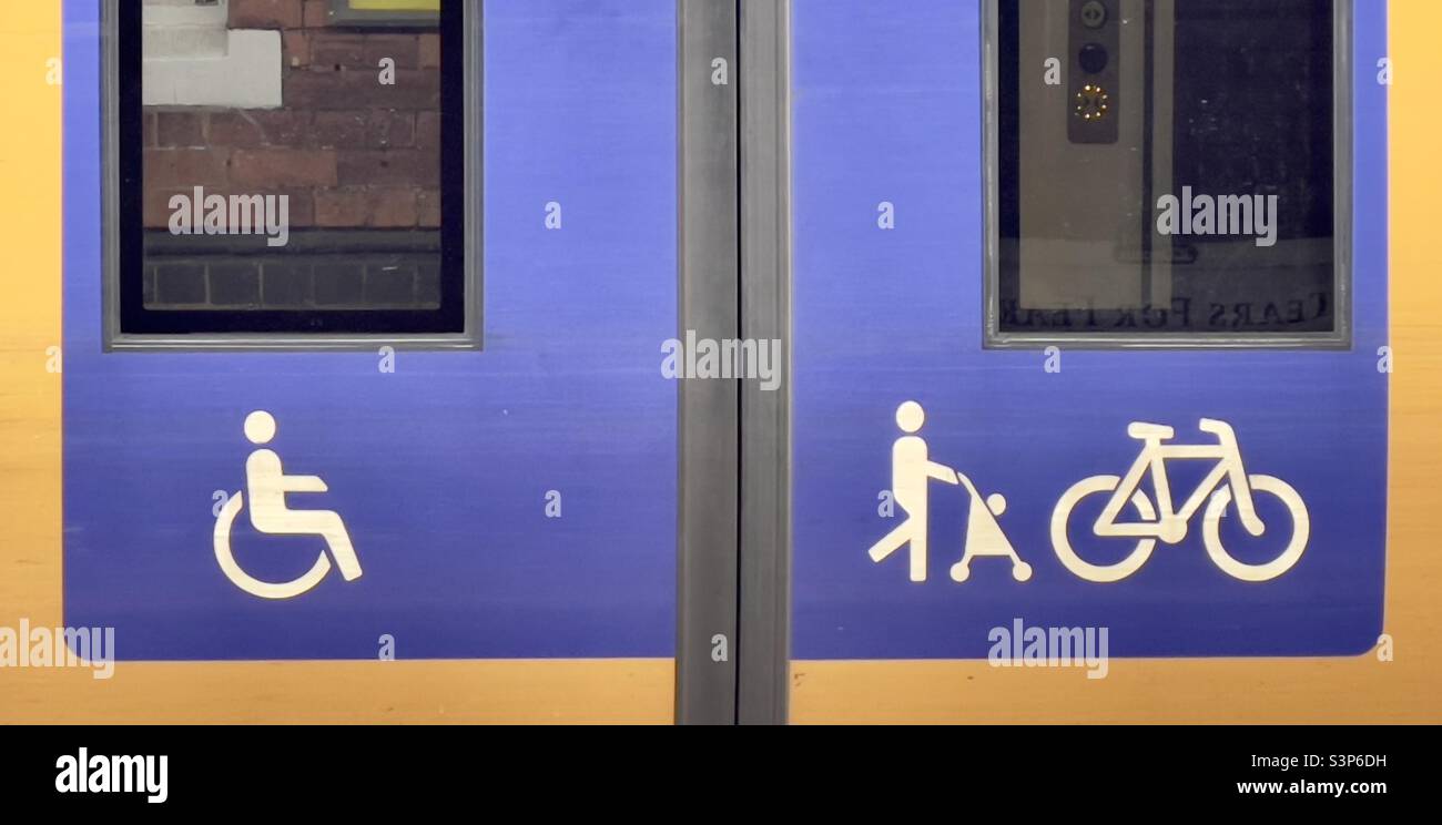 Un primo piano delle porte di un trasporto ferroviario che si trova in una stazione di Worcester e che riporta il simbolo della disabilità insieme a «genitore e bambino» e alla bicicletta Foto Stock
