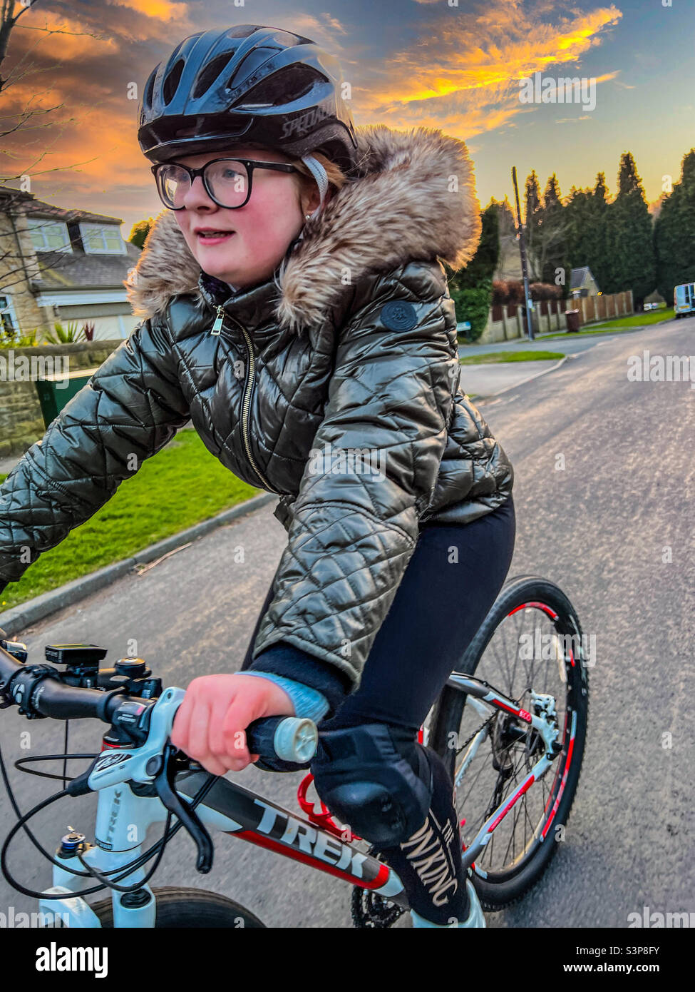 Giovane ragazza che guida la sua mountain bike per strada Foto Stock