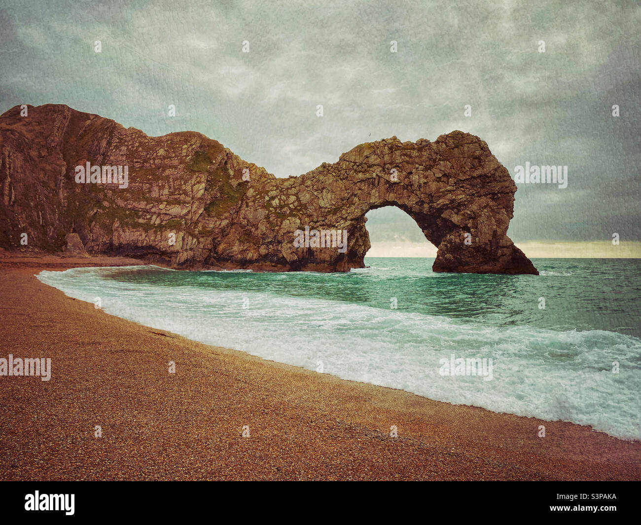 Il famoso arco di pietra calcarea conosciuto come Durdle Door sulla costa meridionale dell'Inghilterra - una destinazione turistica ben visitata. Milioni di anni fa, i dinosauri si gironzavano intorno a questa zona! Foto ©️ COLIN HOSKINS. - Immagine stock catturata con smartphone