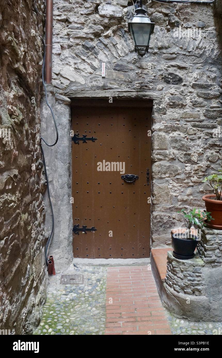 Antica porta in legno adorna una casa nel borgo medievale di Dolceaqua in Italia. Foto Stock