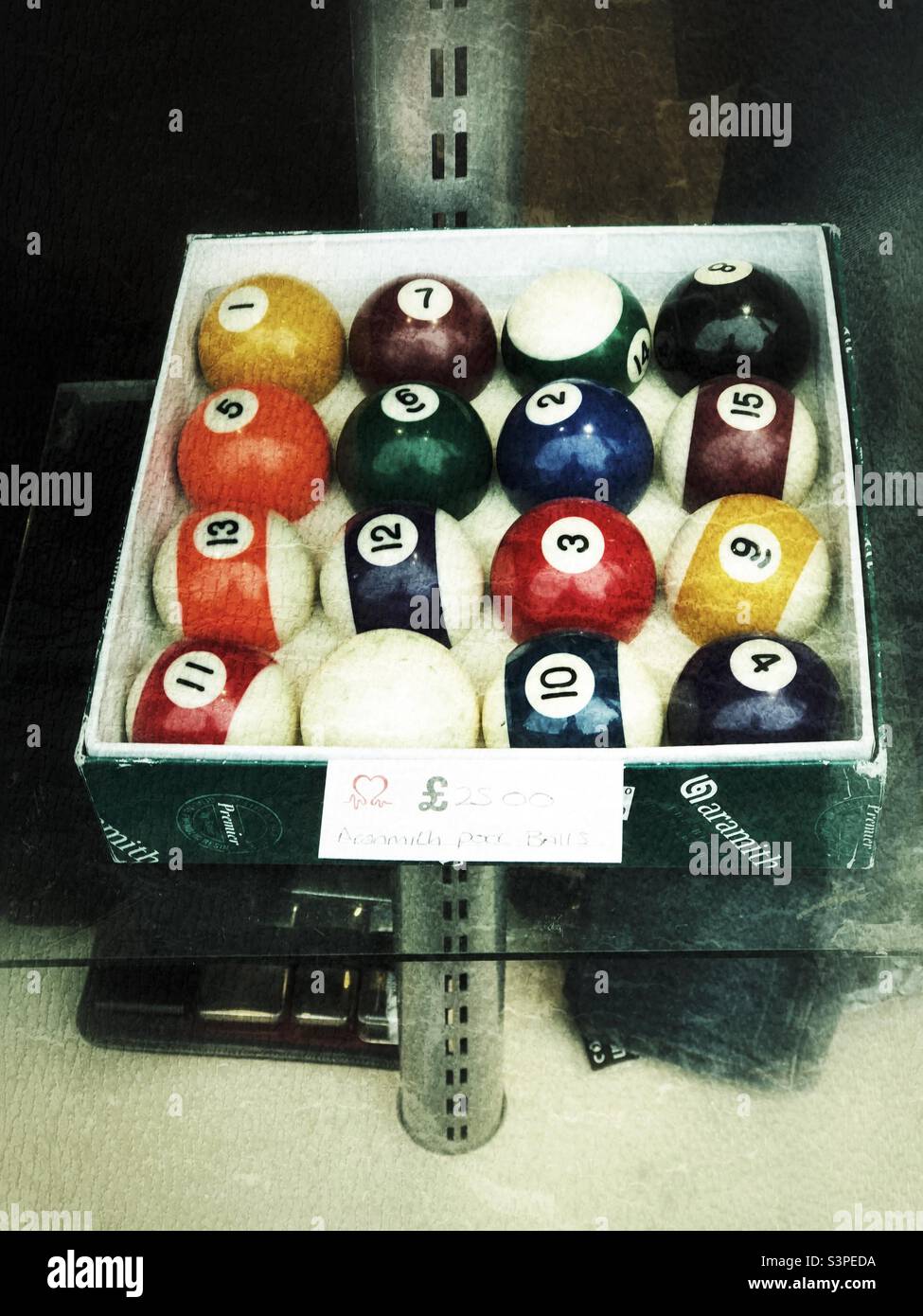 Una scatola di palle da biliardo in vendita in una vetrina Foto Stock