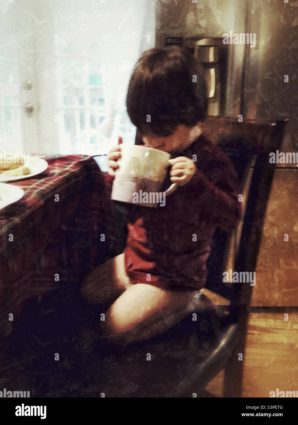 Il bambino prova il caffè della mummia Foto Stock