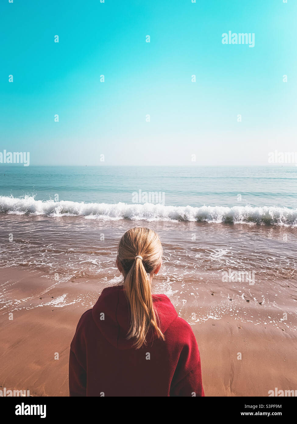 Vista posteriore di una donna che guarda verso il mare - Immagine stock catturata con smartphone