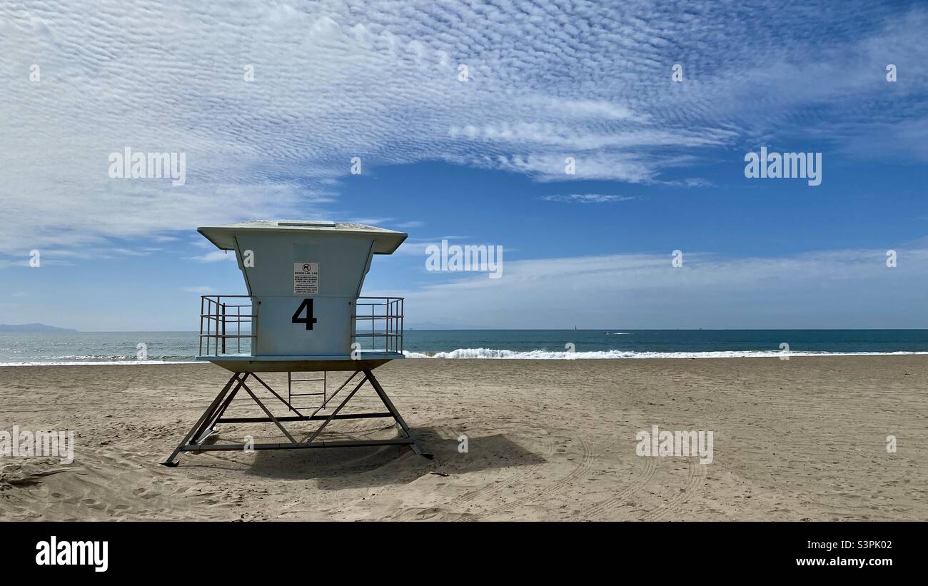 VENTURA BEACH, CA, MAR 2021: Chiudi vista baita bagnino sulla spiaggia sabbiosa. Le onde si infrangono sul vicino Oceano Pacifico. Isole visibili a distanza. Cielo nuvoloso Foto Stock