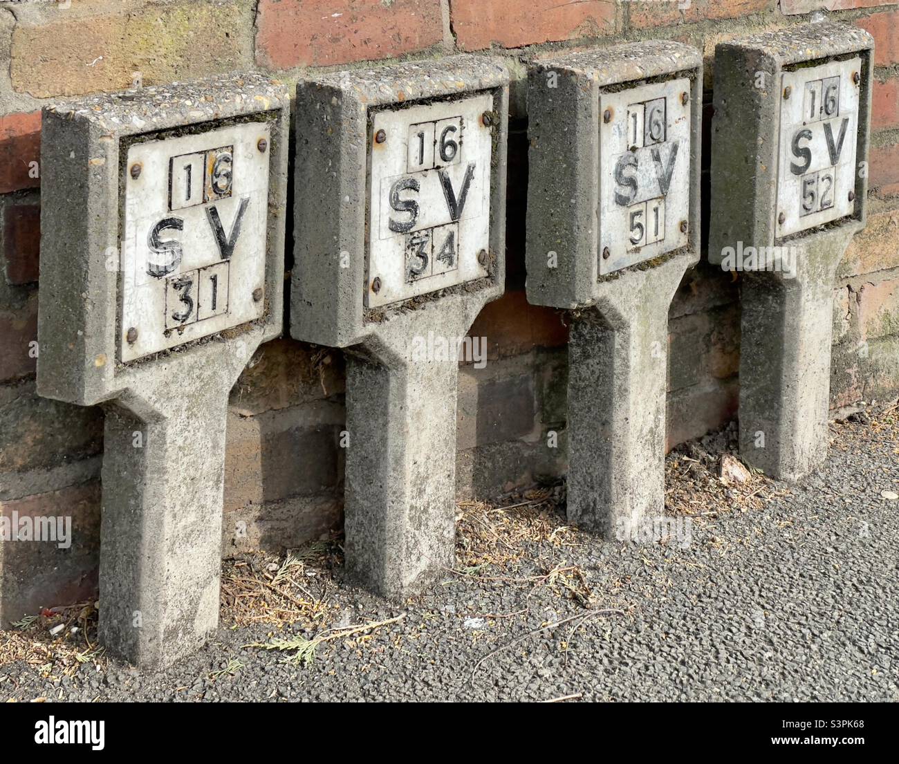 Una fila di marcatori di valvole di schiusa in una strada di Worcester Foto Stock