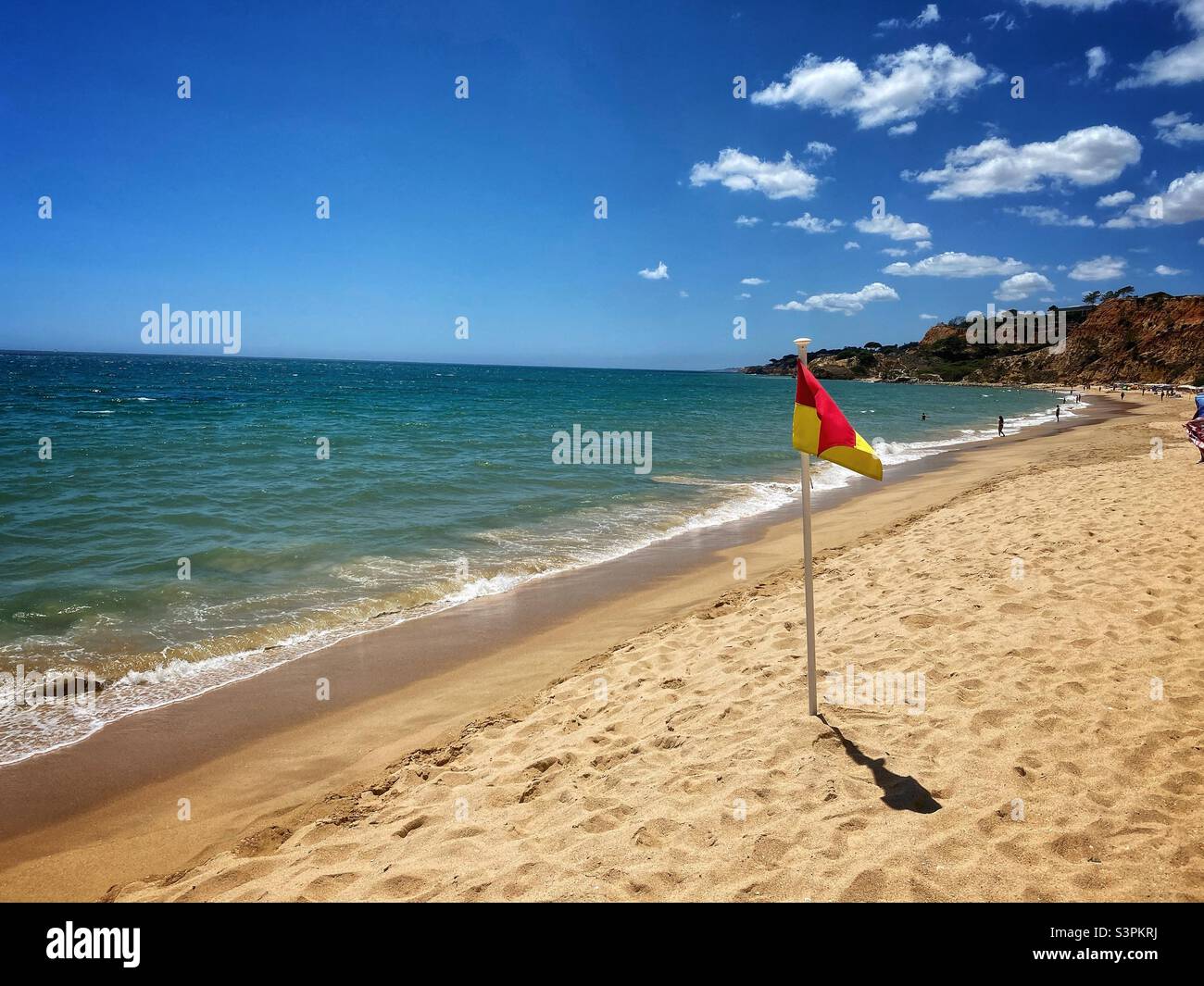 Bandiera nella sabbia su una spiaggia soleggiata in Algarve, Portogallo. Foto Stock