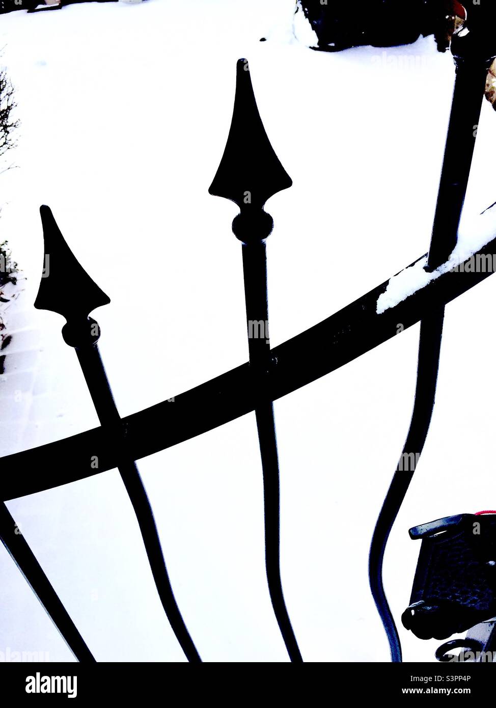 Ferro battuto intrecciato sullo sfondo di neve guidata, Ontario, Canada. Frecce puntate. Acciaio ondulato piegato. Contrasto elevato. Bianco e nero Foto Stock