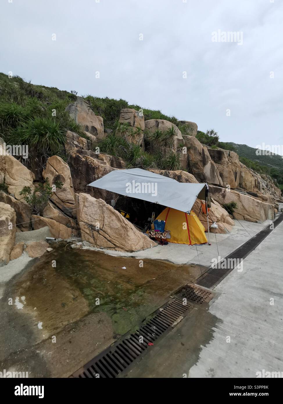 Campeggio vicino alle rocce presso la spiaggia di Shek Pai WAN, isola di Lamma, Hong Kong. Foto Stock
