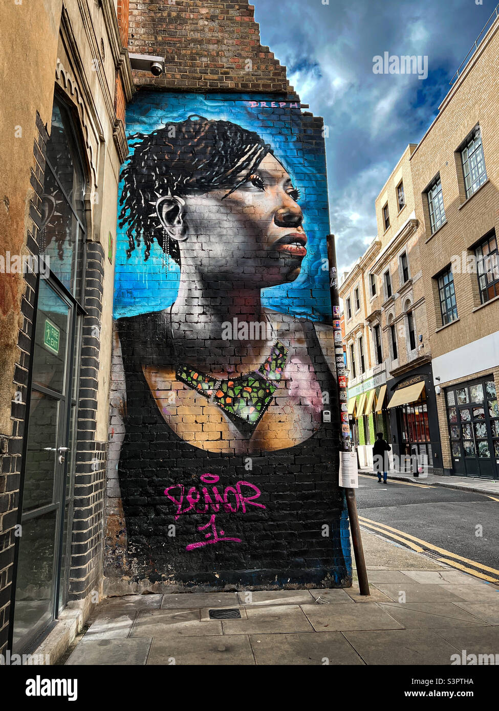 Graffiti Street art di donna su muro di mattoni, Shoreditch, Londra, Regno Unito - Gennaio 2022 - Immagine stock catturata con smartphone
