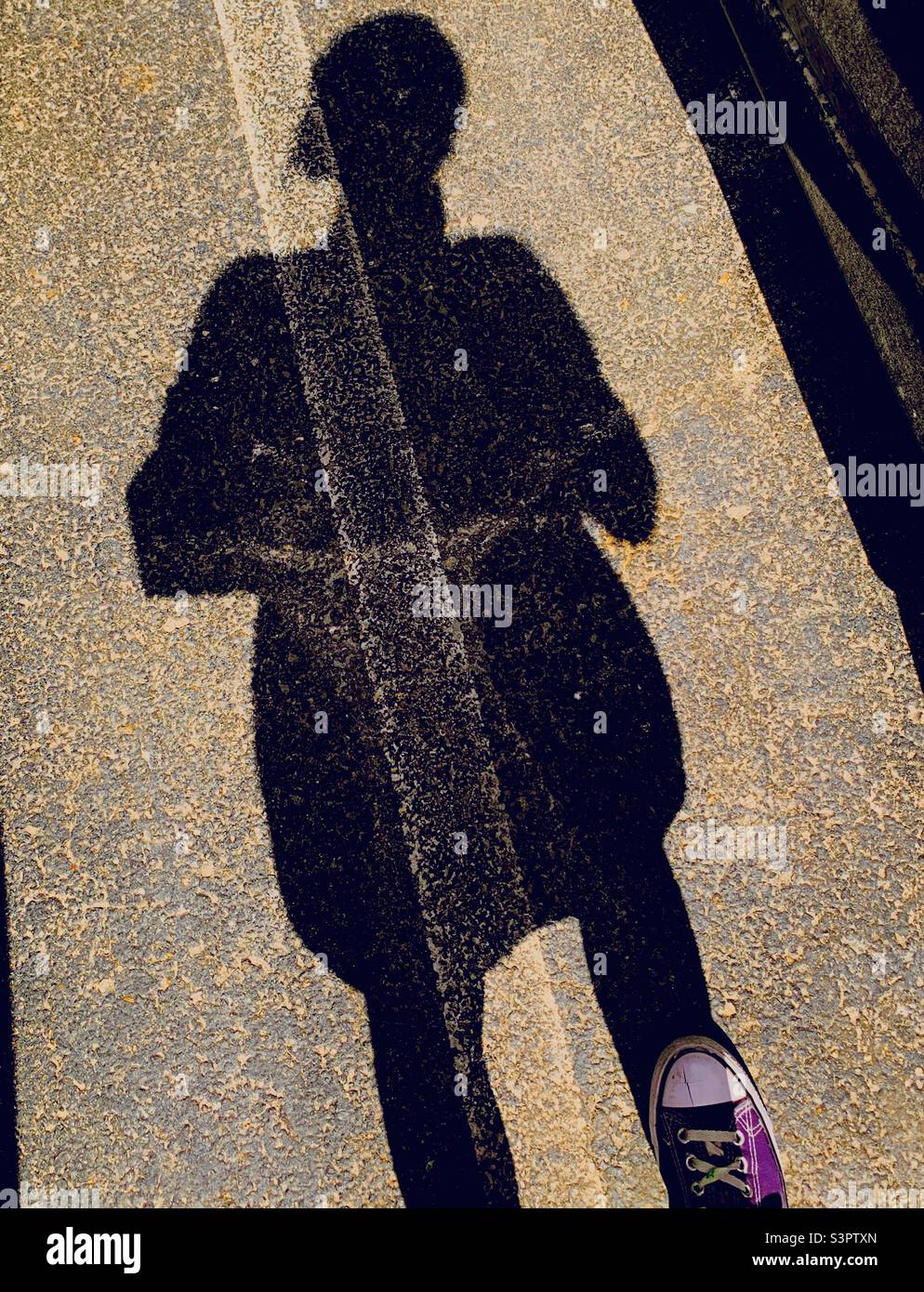 Ombra della donna con scarpa viola Foto Stock