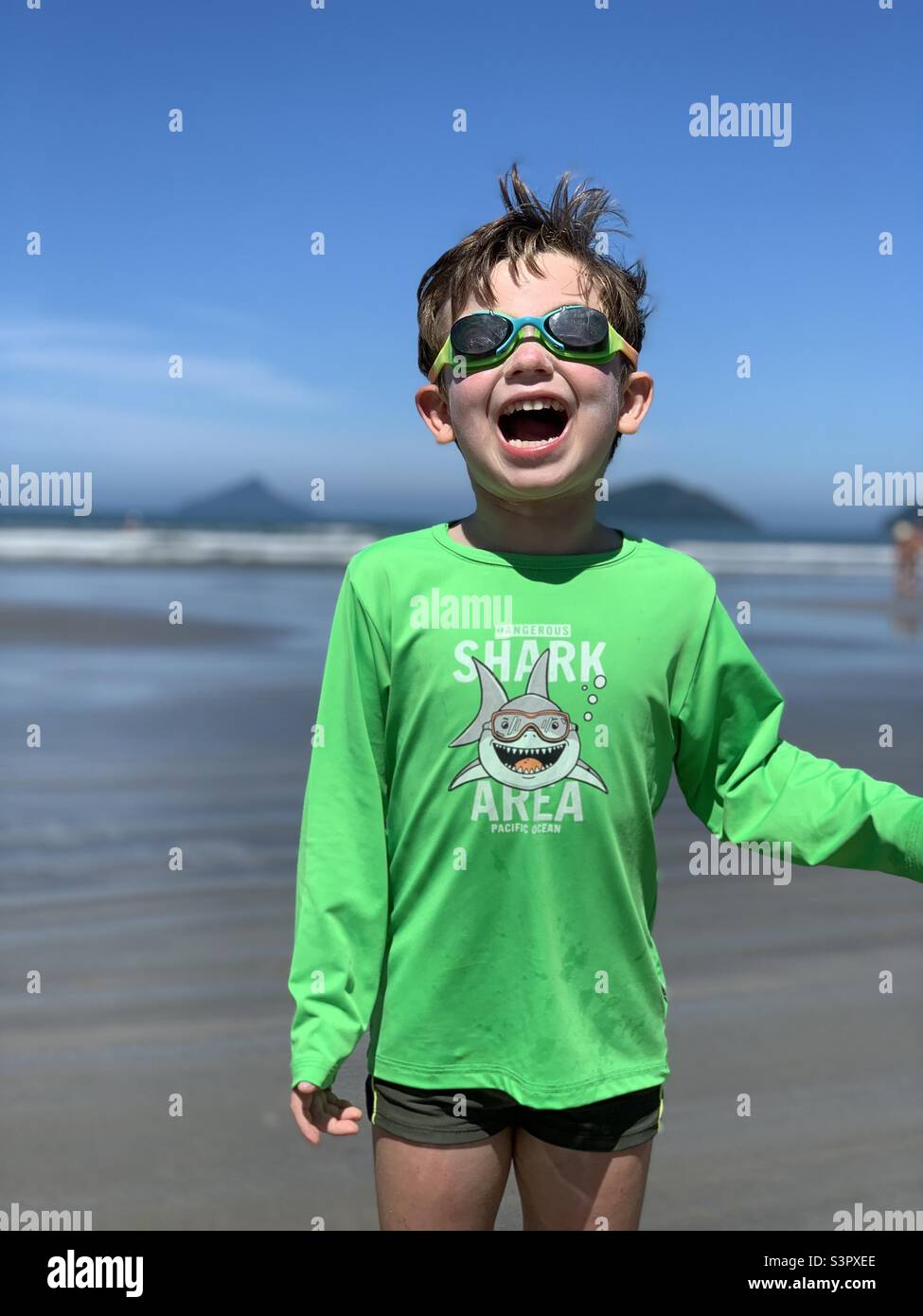 Ragazzo felice che si diverte in spiaggia. Baleia Beach, Sao Sebastiao, Brasile. Foto Stock