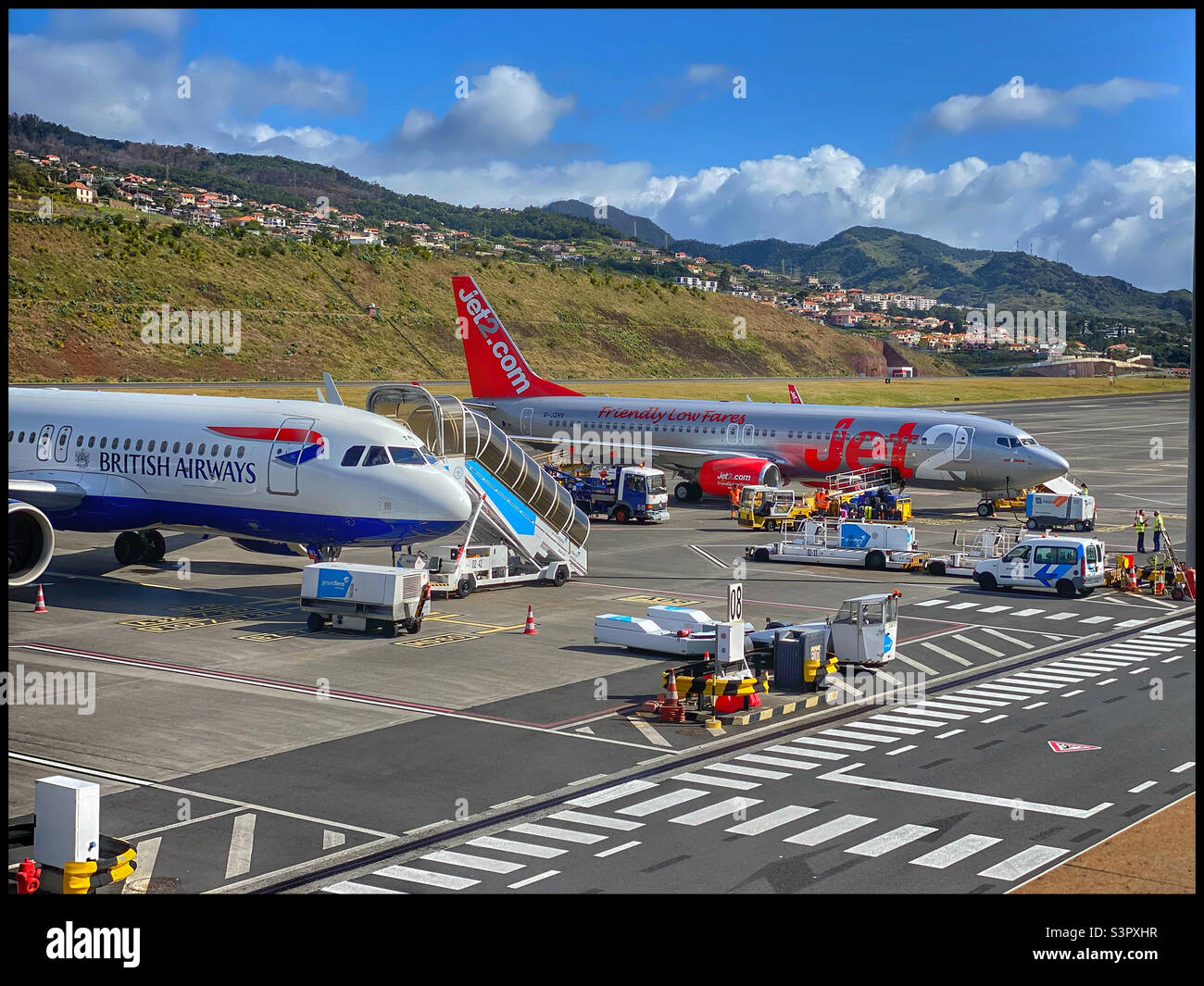 Un aereo della British Airways e un aereo del Jet2 all'aeroporto internazionale di Funchal (aeroporto internazionale Cristiano Ronaldo) a Madeira. Entrambi gli aerei sono in scarico e in attesa di ritorno nel Regno Unito. - Immagine stock catturata con smartphone