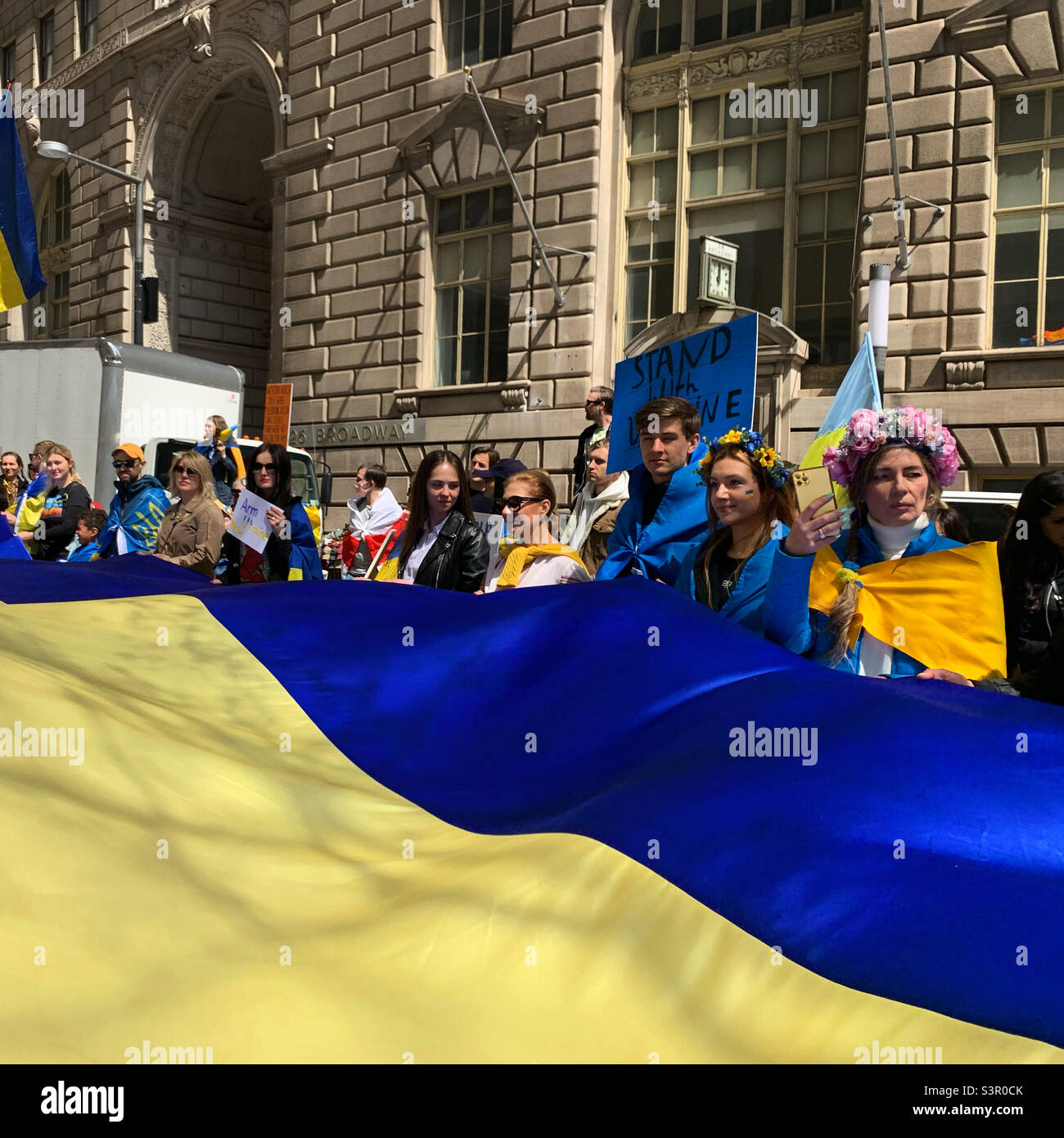 23 aprile 2022, la gente ha una bandiera Ucraina gigante al rally di Arm Ukraine ora, Bowling Green, New York, New York, Stati Uniti - Immagine stock catturata con smartphone