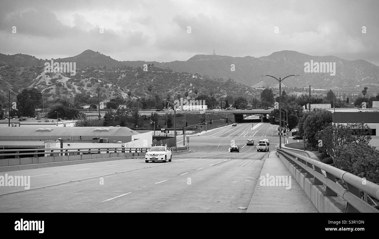 GLENDALE, CA, MAGGIO 2021: Vista lungo la strada a più corsie nella città di Glendale, montagne sullo sfondo. Bianco e nero Foto Stock