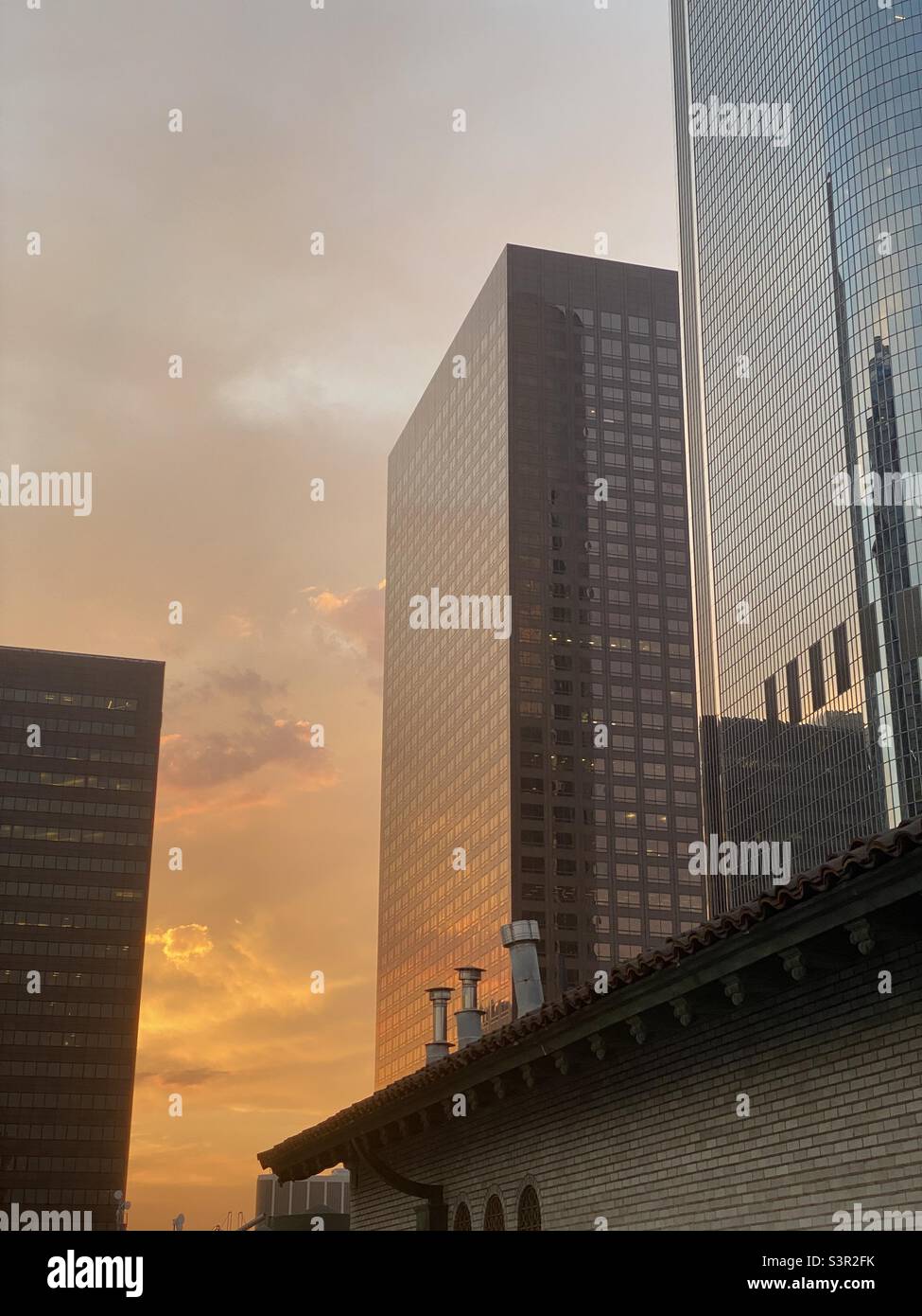 LOS ANGELES, CA, GIUGNO 2021: Guardando i grattacieli che riflettono i toni arancioni del tramonto nel quartiere finanziario del centro - Immagine stock catturata con smartphone