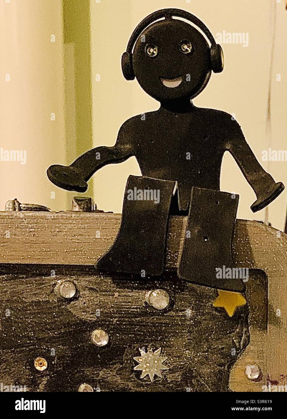 NERDY still life con spazio copia, personaggio giocattolo nero sembra un DJ con un grande sorriso indossando cuffie Foto Stock