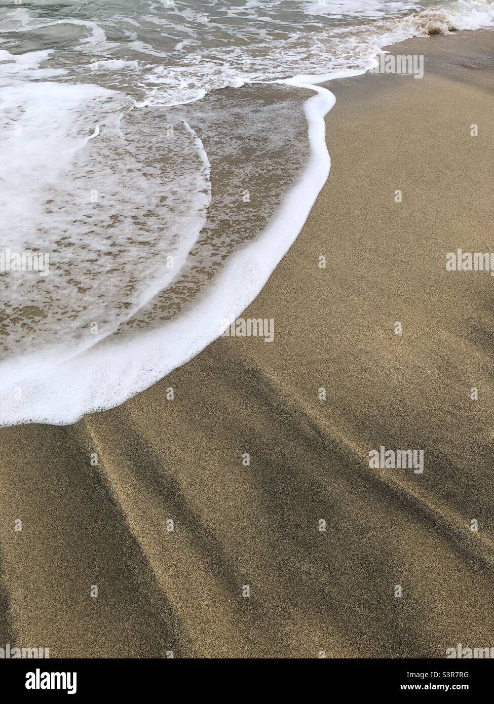 Onde d'acqua di mare su una spiaggia sabbiosa sull'isola di Lewis, Scozia, Regno Unito - Immagine stock catturata con smartphone